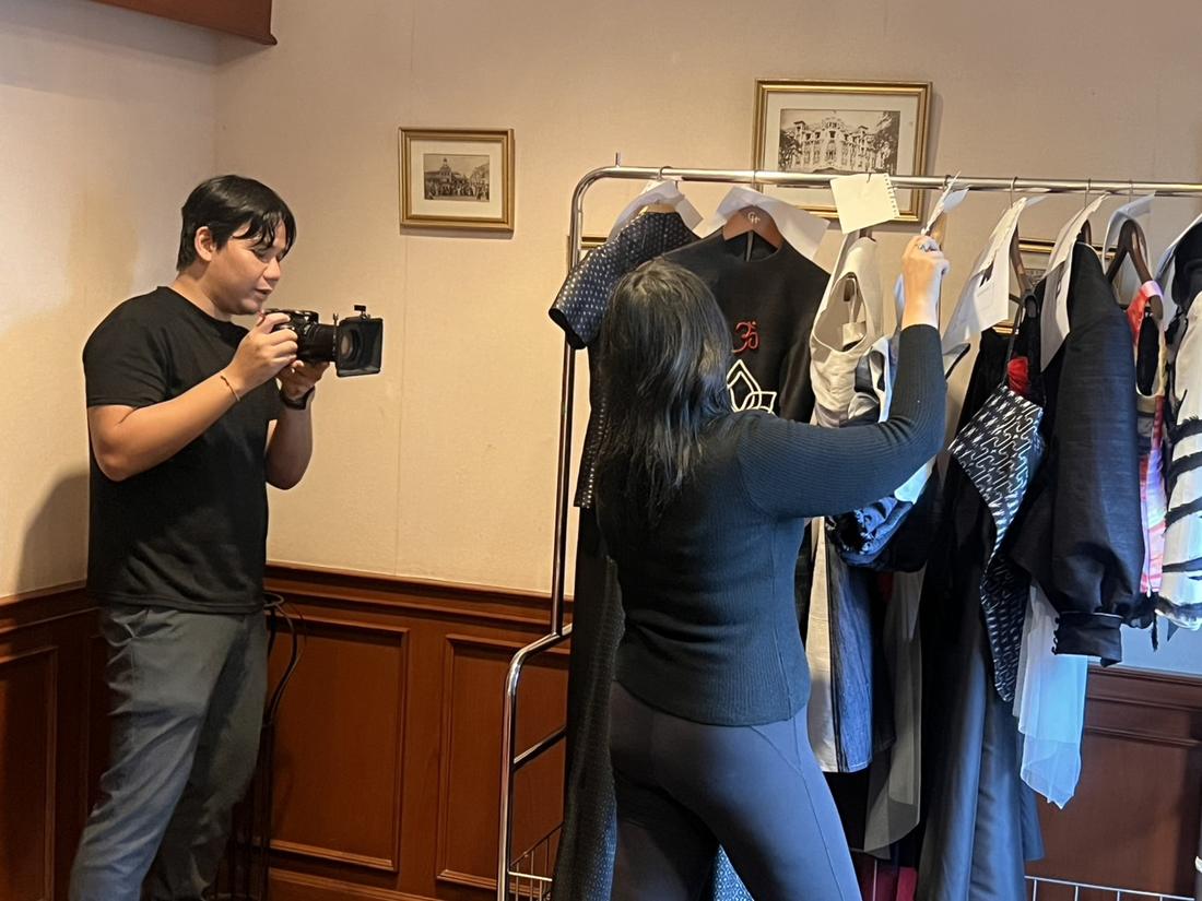 Photographer shooting the collection while Mika arranges the rack