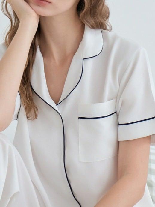 Close-up of a white Dreamwave pyjama shirt with navy piping
