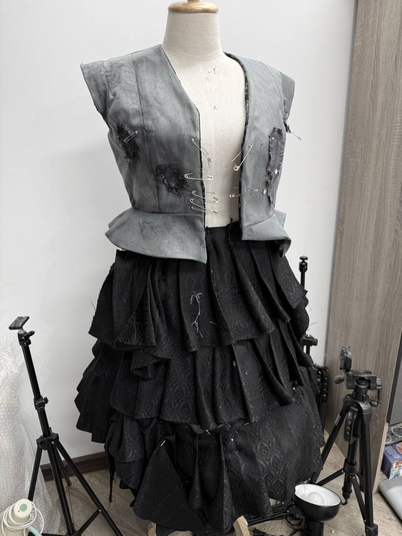 Grey deconstructed vest and black bustle skirt on a dress form