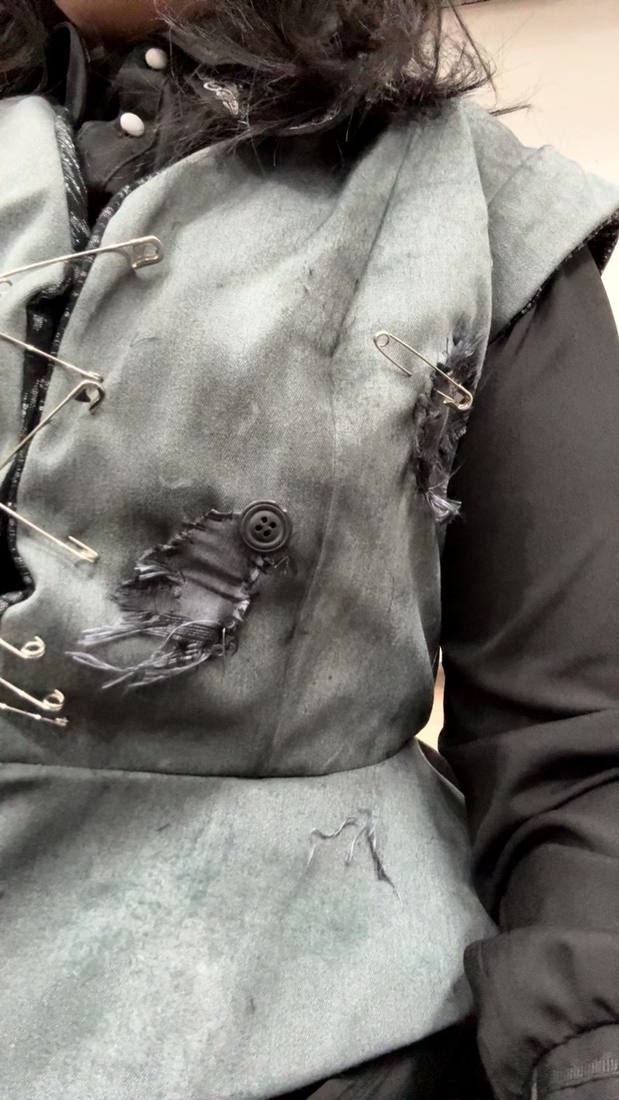 Grey vest detail with safety pins