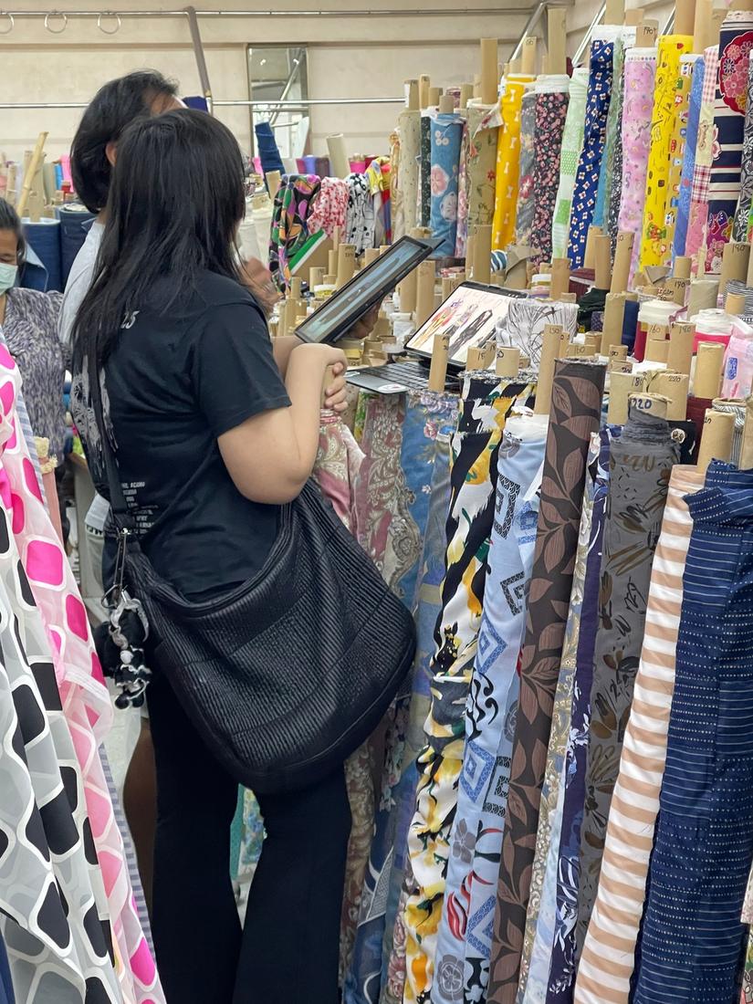 Mika choosing fabrics at a fabric market